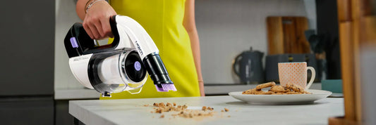 Gtech Multi platinum handheld vacuum cleaner used to tackle food debris on at table surface