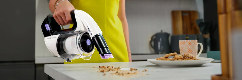 Gtech Multi platinum handheld vacuum cleaner used to tackle food debris on at table surface
