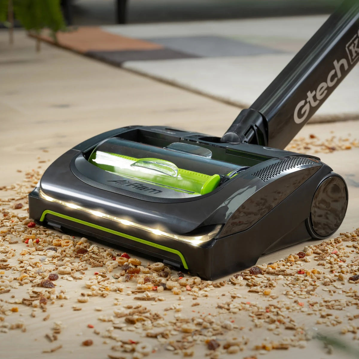 Close up of Gtech AirRAM 2 KP Pet vacuum cleaner cleaning up cereal on wooden floor.