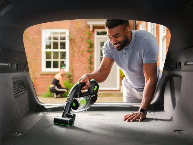 Man using Multi K9 with power head fitted to clean boot of car.