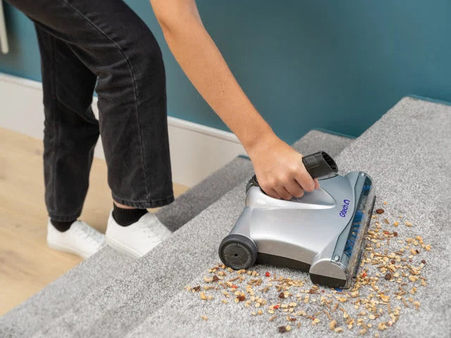 Person using SW02 carpet sweeper in handheld mode on the stairs.