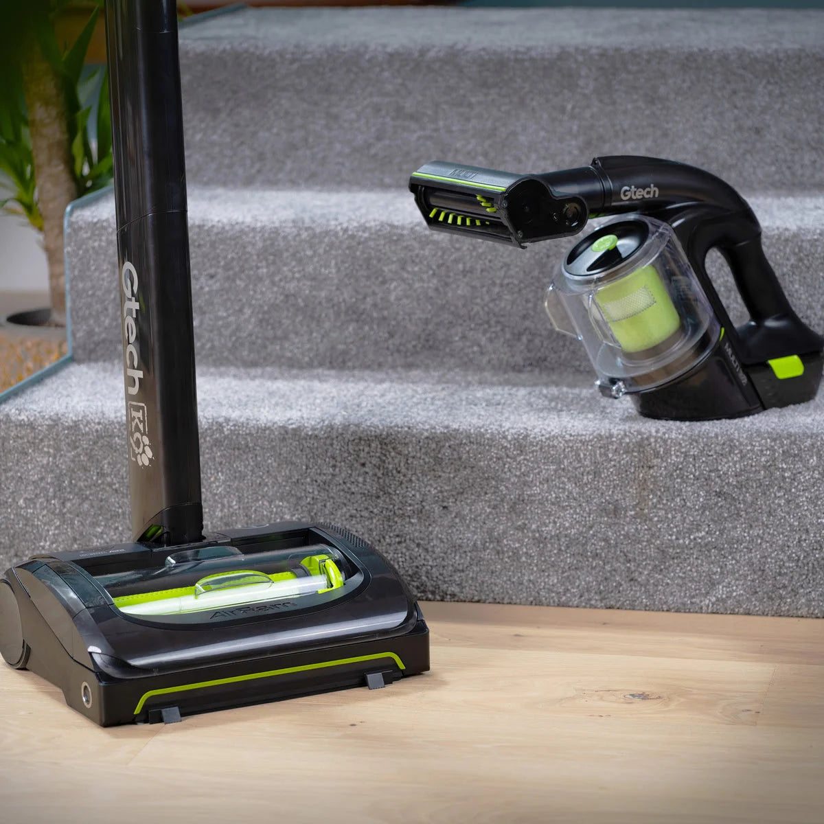 System K9 Pet bundle with AirRAM 2 K9 Pet cordless upright and Multi K9 Pet cordless handheld vacuum sitting on base of carpeted stairs.