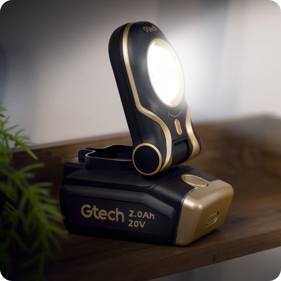 Gtech portable light on a wooden surface with a plant in the background
